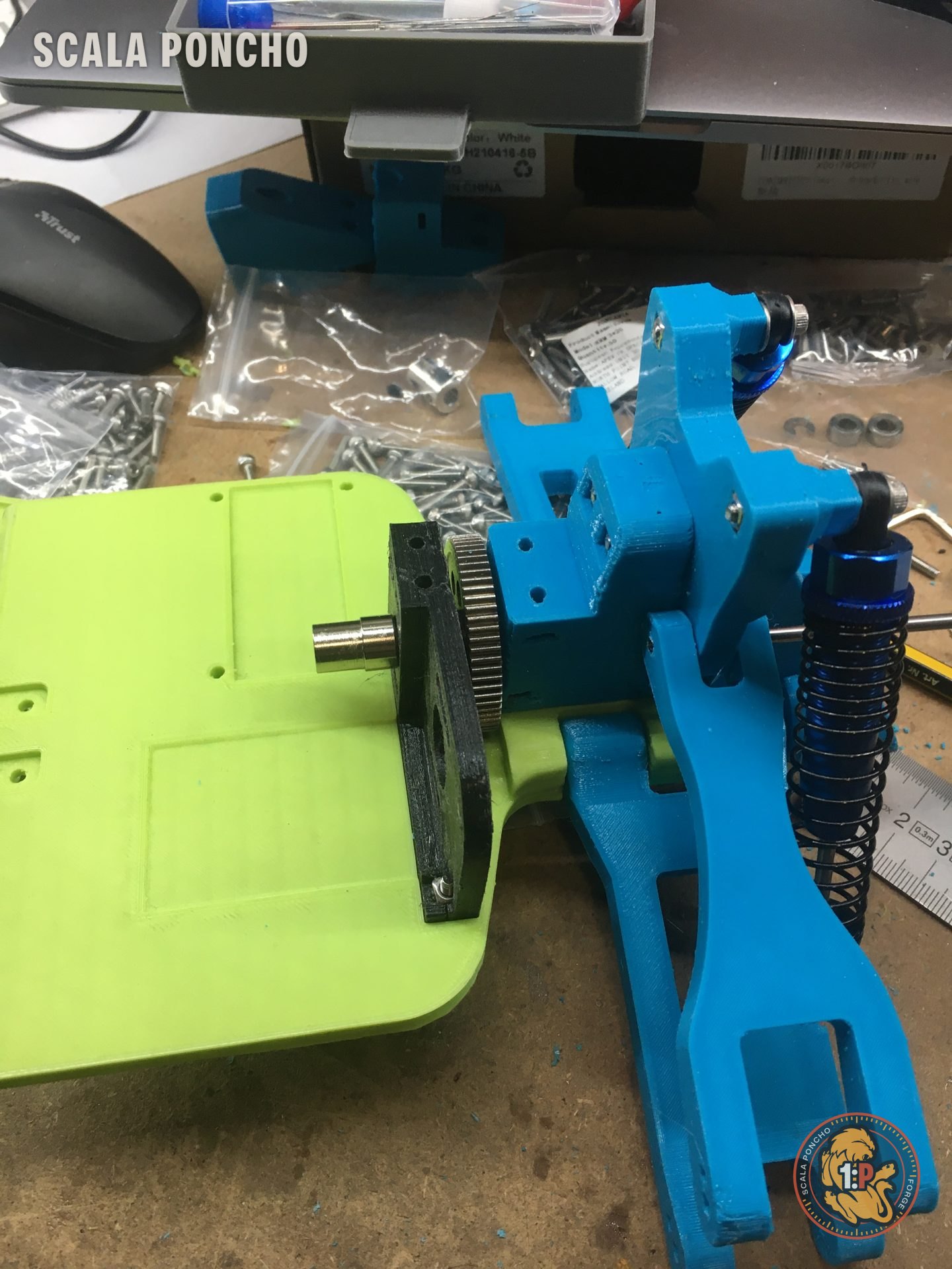 Braccio della sospensione azzurro stampato in 3D con ammortizzatore blu e corona dentata sul telaio verde