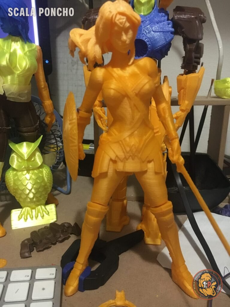 Figure stampate in 3D in filamento giallo e arancione: un robot e un guerriero