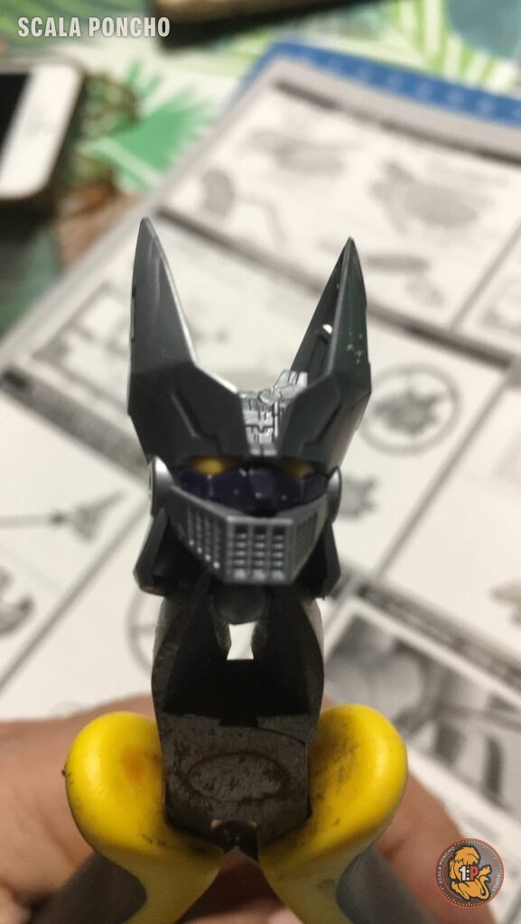 Testa del Grande Mazinger in montaggio tenuta con delle pinze gialle sopra le istruzioni