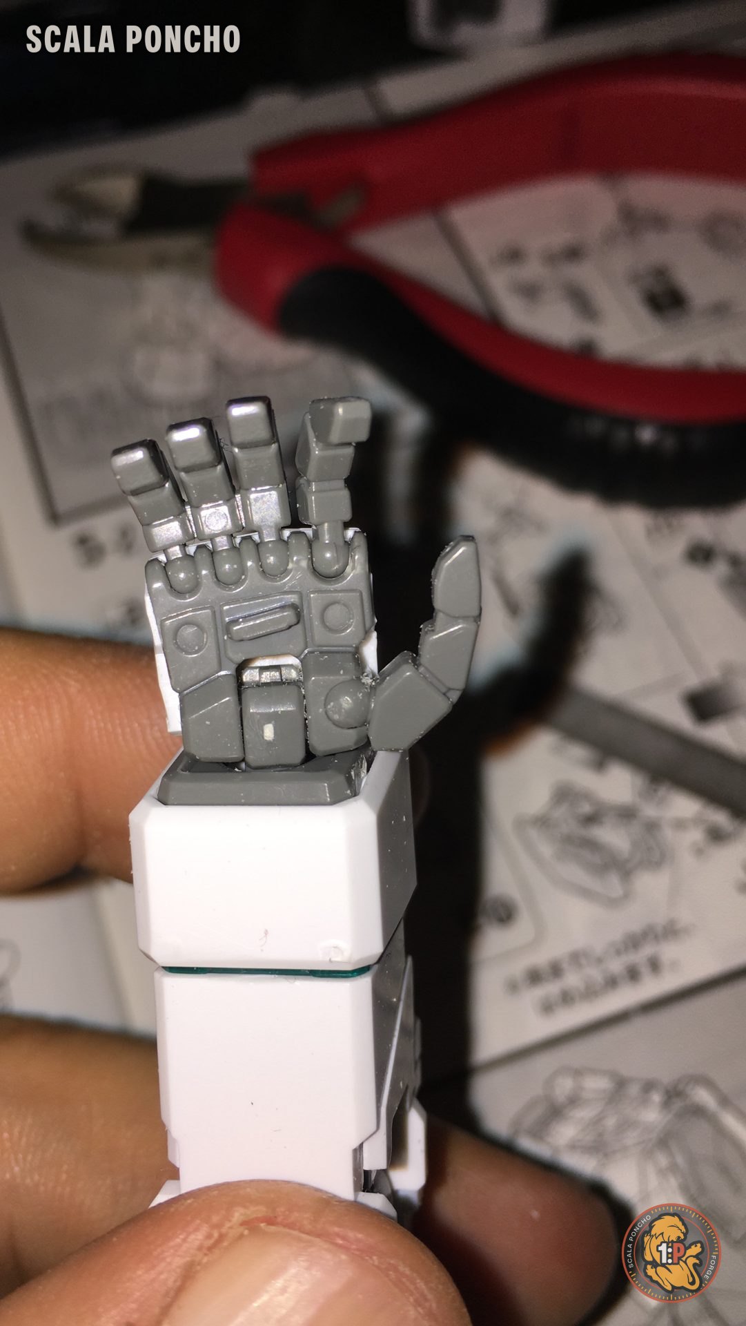 Mano articolata del Gundam Unicorn con le dita mobili tenuta tra le dita