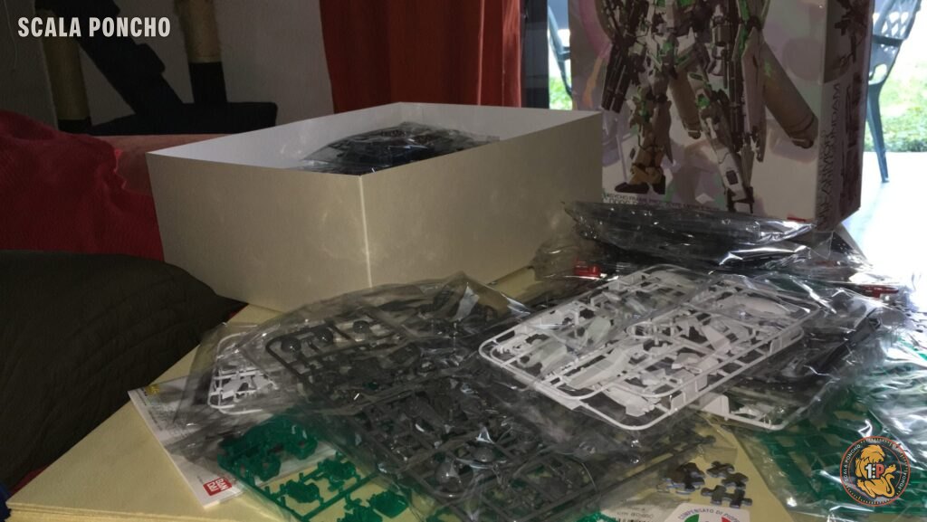 Stampate in plastica bianca, grigia e verde trasparente del kit Gundam Unicorn sparse sul tavolo