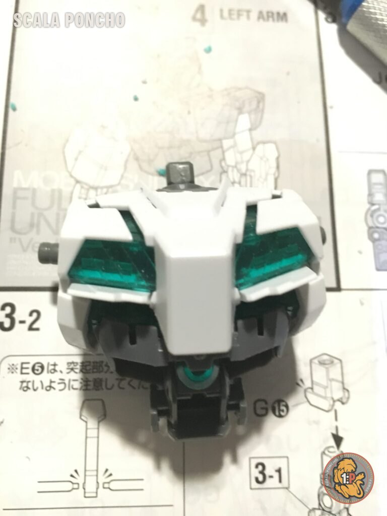 Torso del Gundam Unicorn in costruzione appoggiato sul foglio di istruzioni