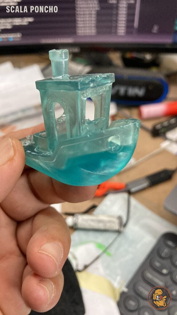 Benchy stampato in resina trasparente verde acqua tenuto tra le dita