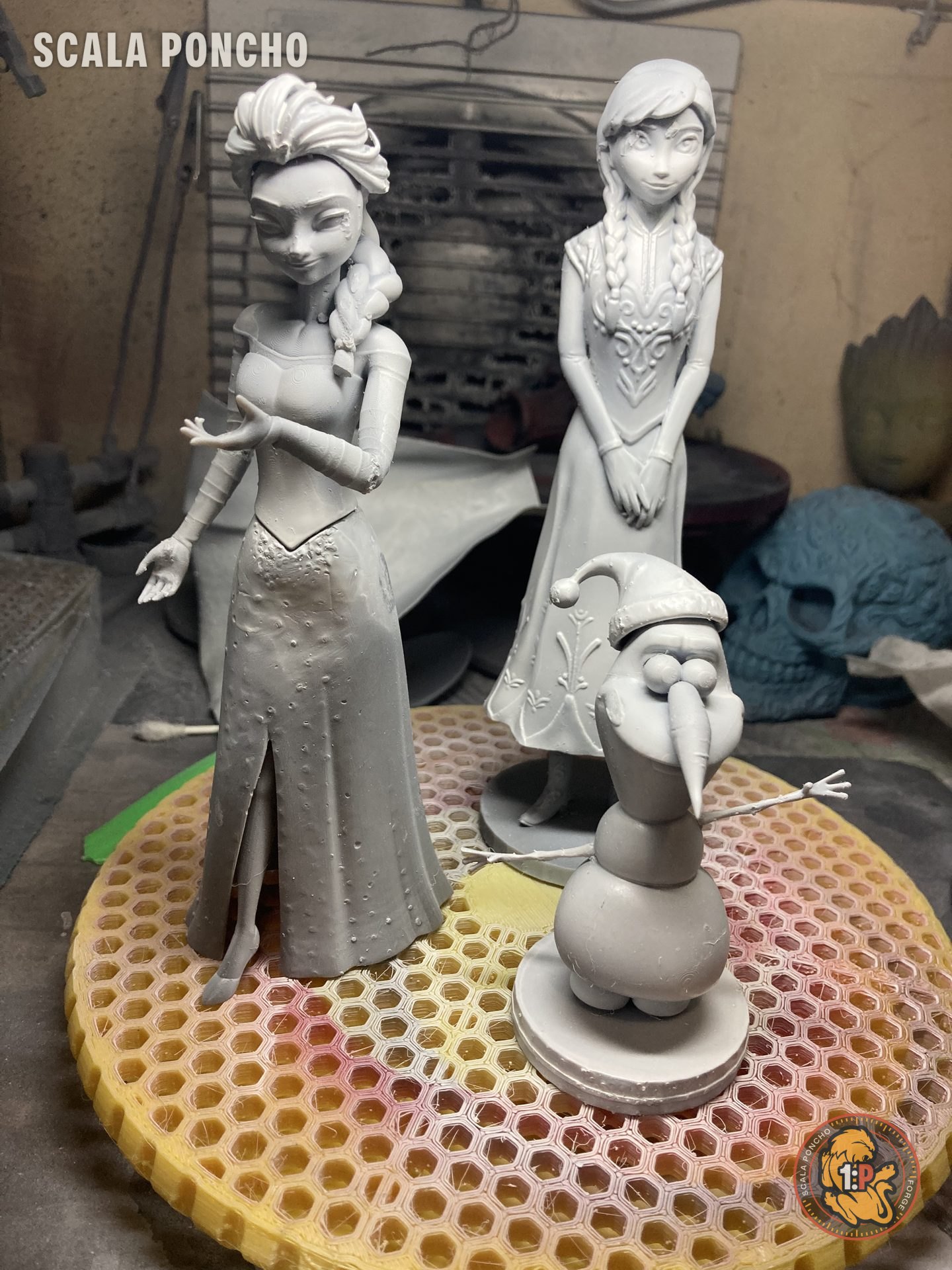 Statuine di Elsa, Anna e Olaf stampate in resina grigia su una griglia