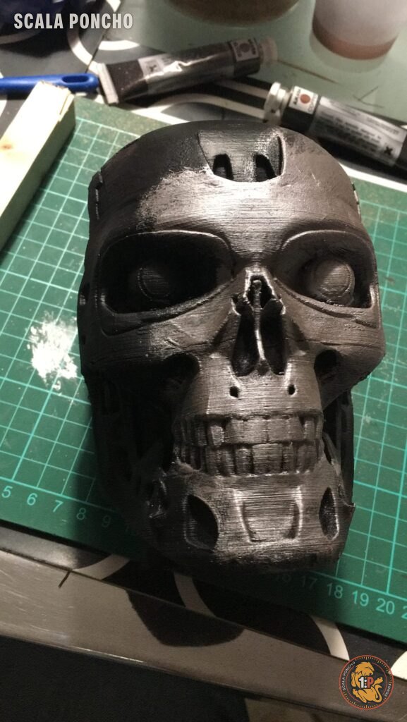 Teschio del T-800 stampato in 3D con una prima mano di argento sul tappetino da taglio