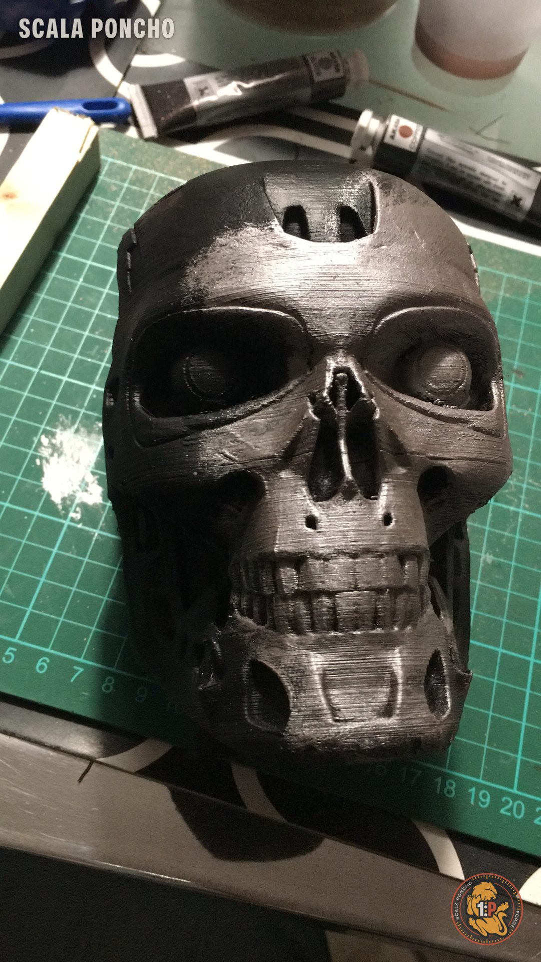 T-800 skull 3D printed with a first coat of silver on the cutting mat
