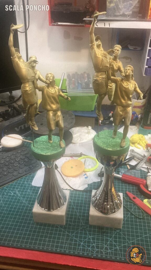 Due trofei di ultimate frisbee dipinti color oro montati su coppe con base verde