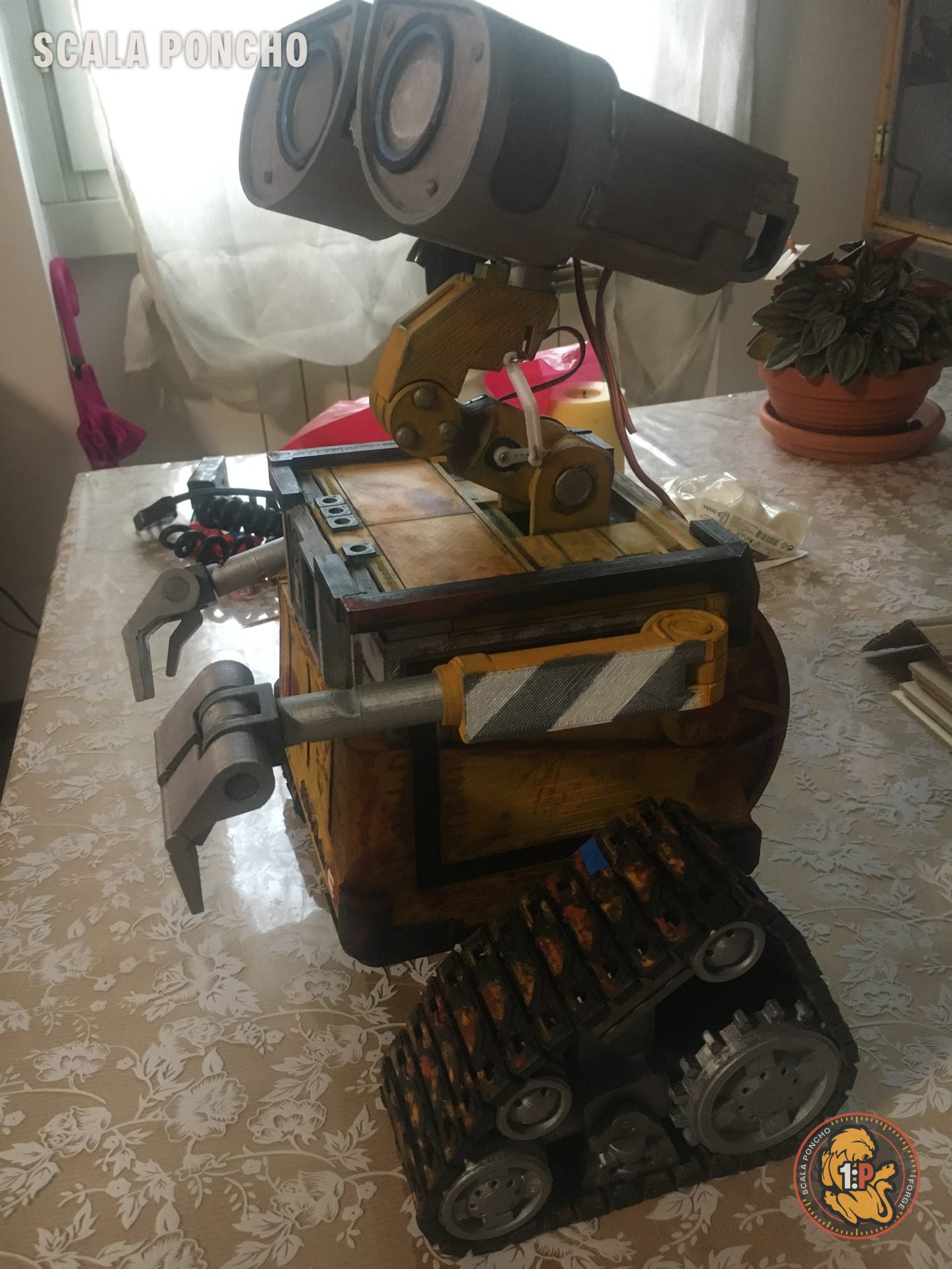 WALL-E finito visto di profilo con la testa sollevata e i cingoli invecchiati